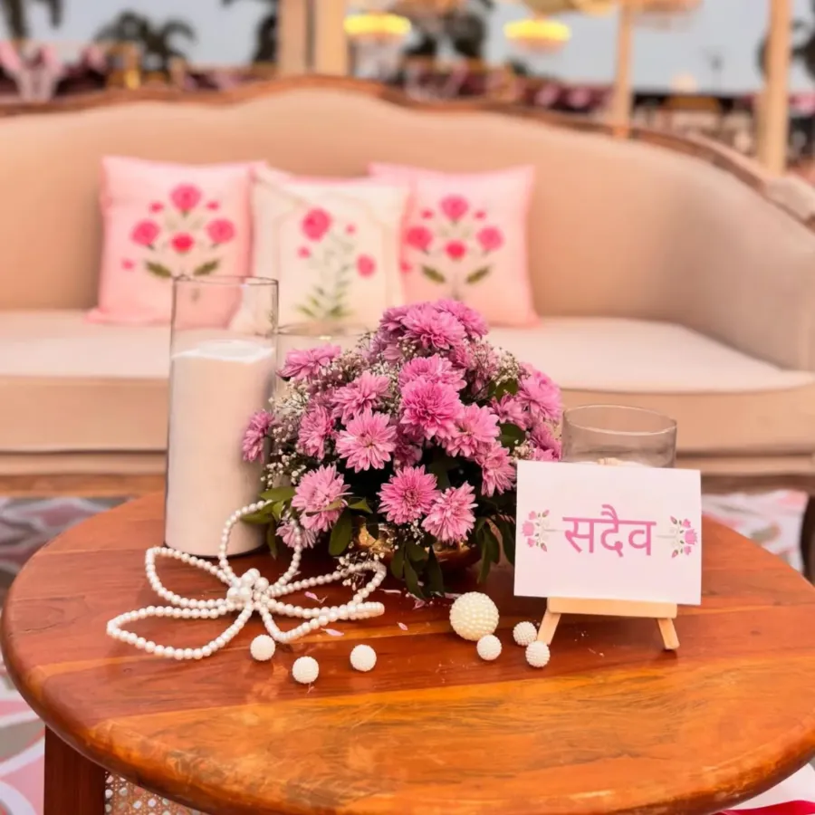 Pink floral centrepiece and a hand-lettered card on a wooden table