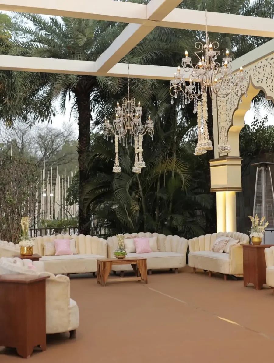 Glass pavilion with chandeliers and white lounge seating