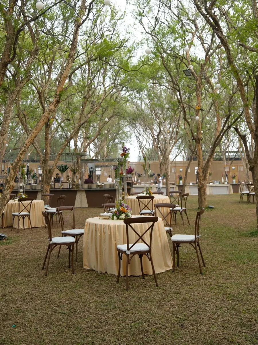 Cocktail tables set out among the trees before guests arrive