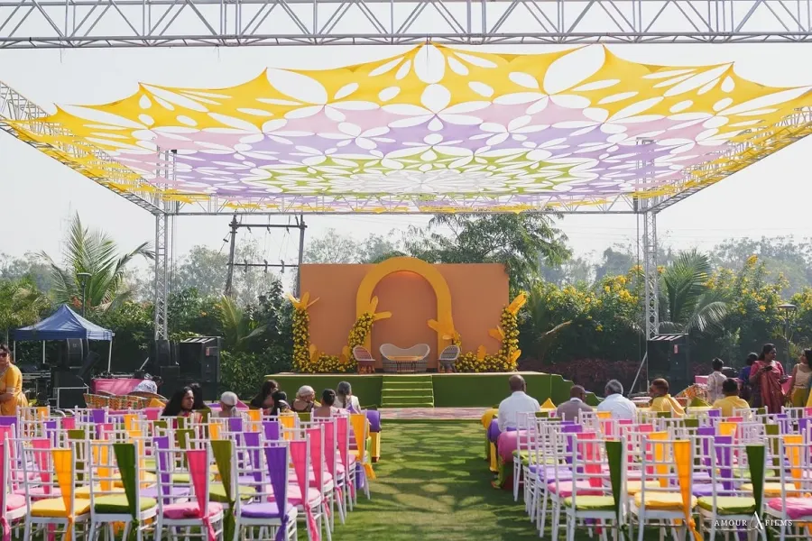 Pastel patterned canopy stretched over colourful banquet seating on a lawn