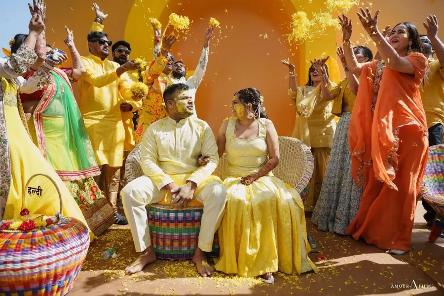 Haldi ceremony in full swing, the couple in yellow surrounded by family
