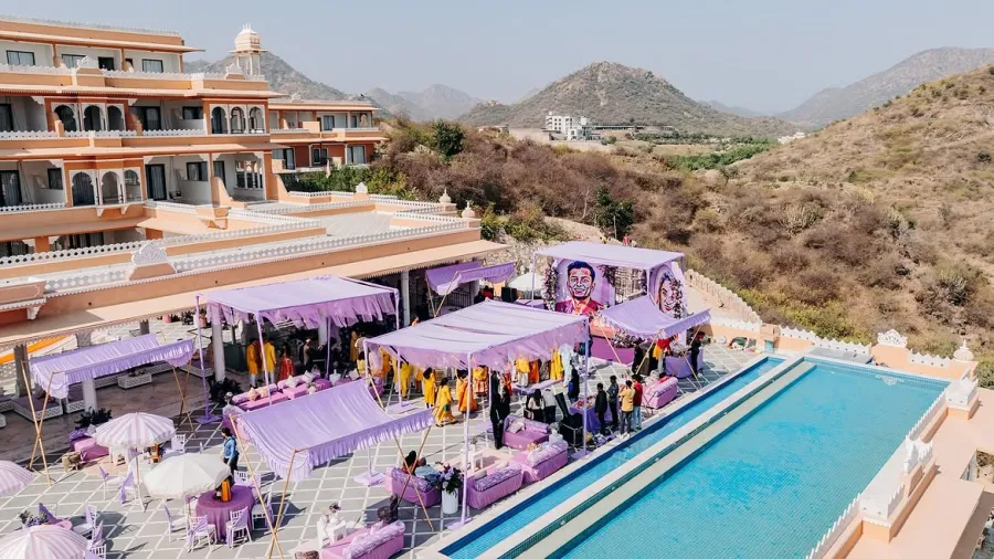 Aerial view of a hillside palace venue with a poolside setup in lavender