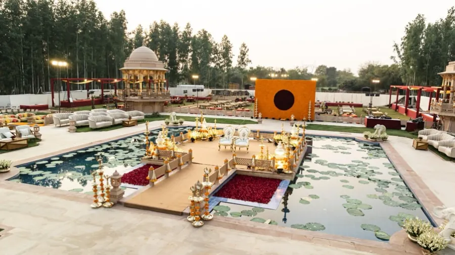 Waterside mandap with walkways across a lily pool