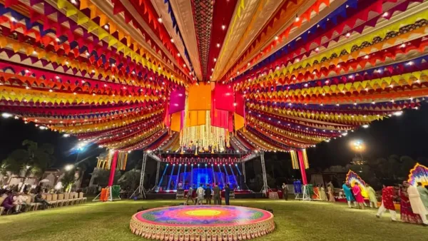 Night-lit canopy of coloured fabric radiating over a round stage
