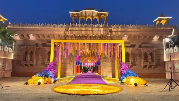 Mandap set against a carved heritage façade with a floral rangoli circle