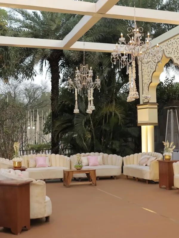 Glass pavilion with chandeliers and white lounge seating