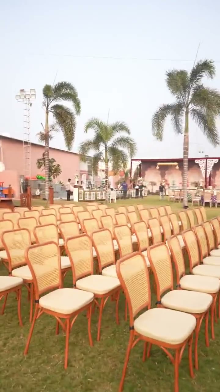 Rows of chairs being placed by hand across the lawn